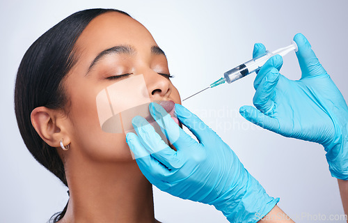 Image of Woman, studio and needle for lips, surgery and cosmetics for skin, facial or collagen by white background. Girl cosmetic surgeon and filler on face, syringe and hands for beauty, skincare and mouth