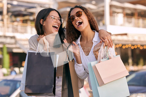 Image of Happy, women friends with shopping bags and at street in city with a smile. Promotion or discount, happiness or retail and excited or cheerful female people shop together for fashion products