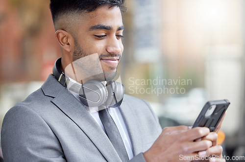 Image of Business man, phone typing and city of a professional with headphones watching a video. Urban, smile and Indian male person with work travel, mobile and happiness with cellphone web and mockup