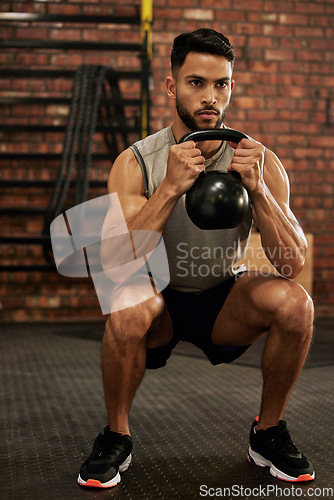 Image of Bodybuilder, fitness and man with kettle bell in gym for exercise, strength training and workout. Sports, challenge and serious male person squat with weights for wellness, healthy body and muscles