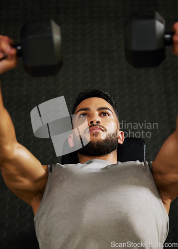 Image of Bench press, workout and man with weight in gym for fitness, bodybuilder training and exercise. Sports, strong muscle and serious male person lifting weight for wellness, healthy body and strength