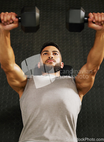 Image of Bench press, fitness and man with weights in gym for exercise, bodybuilder training and workout. Sports, strong muscle and serious male person lifting weight for wellness, healthy body and strength