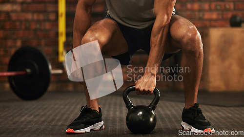 Image of Sports, kettlebell and male athlete doing a workout in the gym for strength, health and motivation. Fitness, strong and closeup of a man doing an arm exercise with weights and squats in sport center.