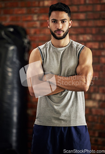 Image of Fitness, muscle and portrait of man in gym with arms crossed for confidence, motivation and pride. Exercise, workout and serious face of confident bodybuilder, personal trainer or sports club owner.