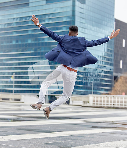 Image of Happy, jump and business man in city for celebration, success and winner. Excited, promotion and wow with male employee jumping in urban outdoors for achievement, motivation and bonus target