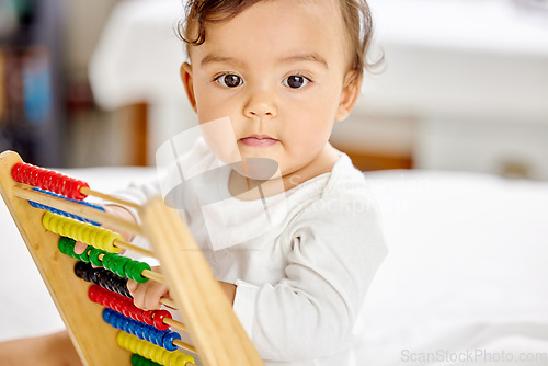 Image of Abacus, bedroom and baby play with toy for learning, child development and motor skills. Family home, newborn and face of adorable child with educational toys, counting beads and playing in bed