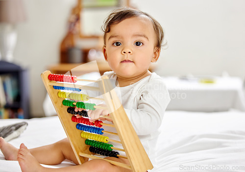 Image of Abacus, bed and portrait of baby with toy for learning, child development and motor skills. Family home, newborn and face of adorable child with educational toys, counting beads and fun in bedroom
