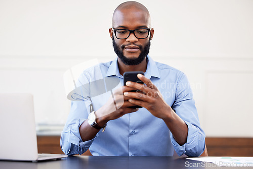 Image of Black man, phone and desk in office with search on internet for networking, email or social media. Online research, digital marketing and businessman with glasses, cellphone and laptop at start up.