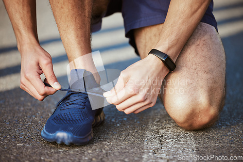 Image of Man, hands and tying shoes for running, fitness or cardio exercise on asphalt road in the outdoors. Hand of male person, athlete or runner tie shoe getting ready for exercising or training on street
