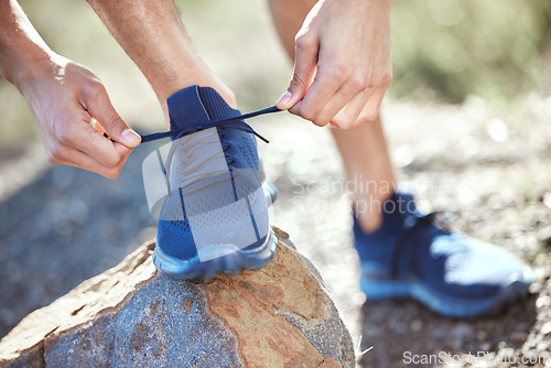 Image of Man, hands and tie shoes for running, fitness or getting ready for workout, hiking or walk in nature. Hand of male person, hiker or runner tying shoe for trekking, run or cardio exercise outdoors