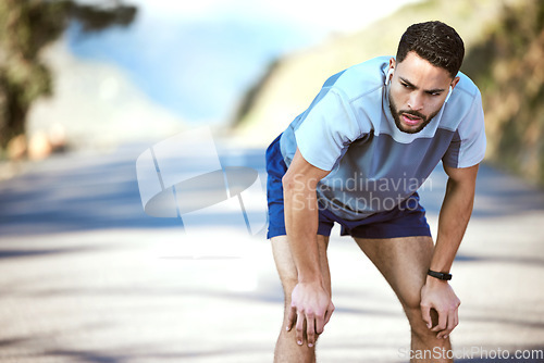 Image of Fitness, man and tired outdoor with music on a run or workout with earphones. Male athlete person or runner listening to audio on a road for cardio training, running or exercise break to breathe