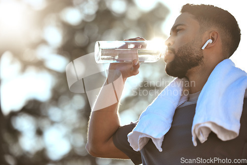 Image of Man, fitness and drinking water in nature for sustainability, hydration or break after running workout or exercise. Male person or runner with natural drink for healthy wellness or rest from run