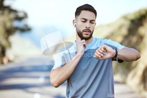 Image of Man, fitness and running with watch for pulse, heart rate or checking performance after cardio workout in nature. Male person, athlete or runner looking at wristwatch during outdoor run or exercise