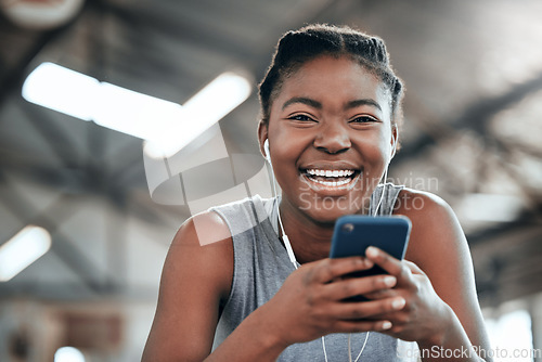 Image of Phone, earphones and portrait of black woman in gym for fitness, sports or exercise. Smartphone, face and African female athlete on social media break, web and music after workout, training and smile