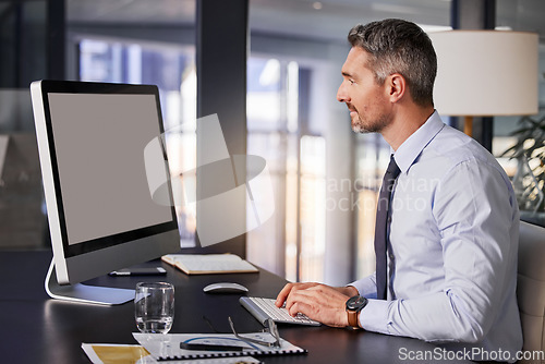 Image of Computer, email and report with a business man typing while sitting at a desk in his office at work. Planning, research and technology with a male manager working online for finance or accounting