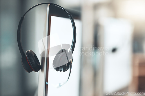 Image of Call center, headset and computer in empty office for customer service business with technology. Telemarketing job, headphones and microphone on monitor at help desk for crm, networking and support.