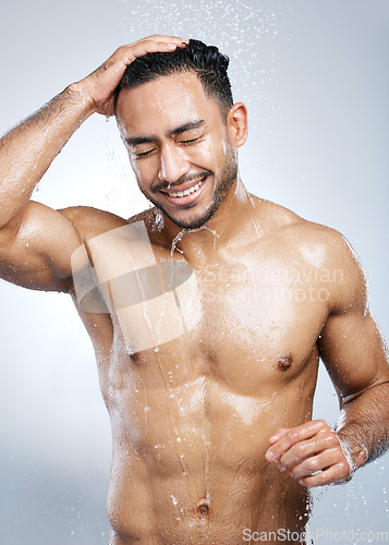 Image of Man in shower with smile, washing body and happiness, hygiene and healthy person on studio backdrop. Water, skin and hair care, happy male model cleaning with splash on background with bathroom spa.