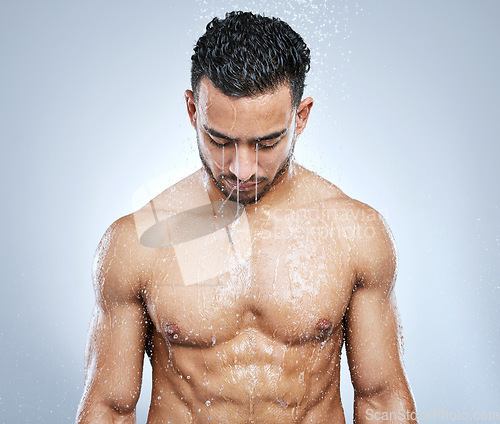 Image of Man in shower with water, cleaning and body hygiene with fresh wellness, healthy clean and studio backdrop. Cleansing, skin and hair care, male model washing with skincare on background bathroom spa.