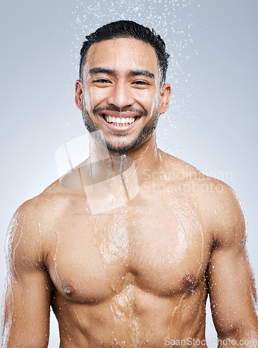 Image of Portrait of man in shower with smile, cleaning and hygiene for healthy body and studio backdrop. Water, skin and hair care, happy male model washing with skincare on background with bathroom spa.