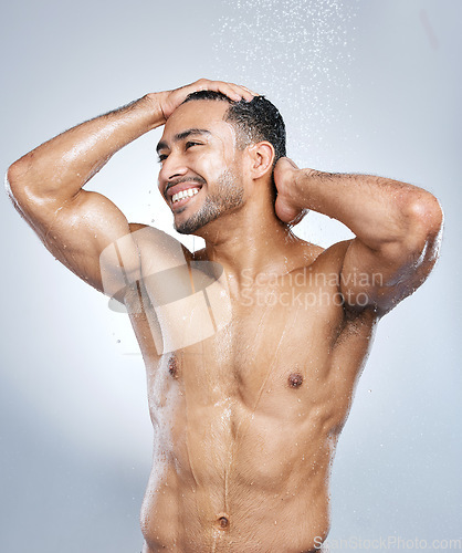 Image of Man in shower with smile, cleaning and water for hygiene with shampoo, healthy body and studio backdrop. Beauty, skin and hair care, happy male model washing with muscle on bathroom background spa.