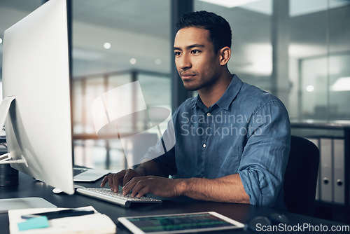 Image of Typing, man and programmer on computer in office at night for deadline. IT, focus and male coder, engineer or person programming, coding and writing software, development and information technology.