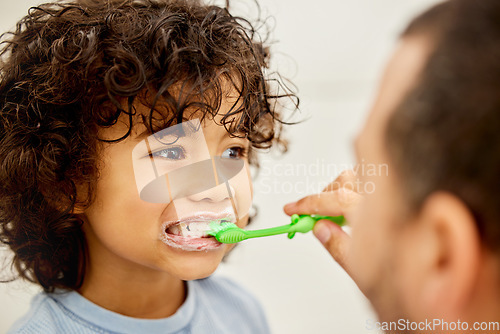 Image of Child, brushing teeth and father helping in a bathroom with dental health and cleaning. Morning routine, toothbrush and kid with dad together showing hygiene care of mouth at home with grooming