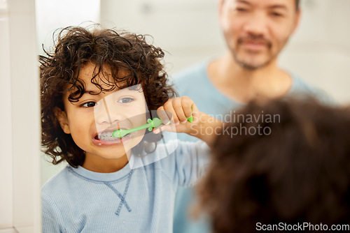 Image of Face, mirror and child brushing teeth in a family home bathroom for health and wellness. Reflection of a latino boy kid with his father to learn about dental, oral and mouth care with a toothbrush