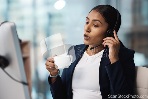 Image of Call center, customer service and coffee with a business woman using a headset while consulting at work. Support, contact us or crm with a young female employee consulting in her telemarketing office