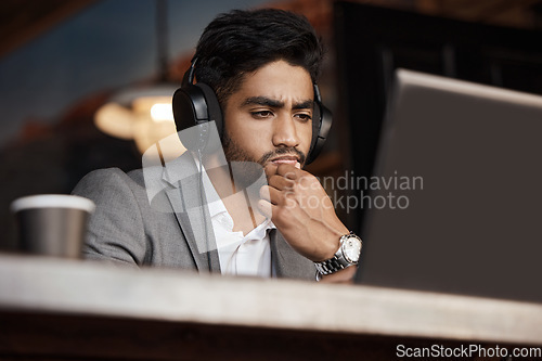 Image of Young business man, thinking and coffee shop with headphones, laptop or plan for schedule, report or analysis. Indian businessman, solution and ideas with brainstorming, web design and music in cafe