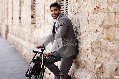 Image of Bicycle, portrait and happy business man in city for carbon neutral, sustainable and transport. Bike, commute and Indian male person on cycling break, smile and relax while traveling in India