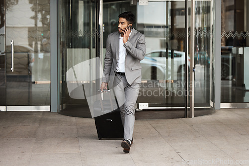 Image of Phone call, travel and luggage with a business man walking in the city for an international trip. Mobile, communication and suitcase with a young male employee talking while on a global commute