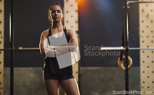 Image of Crossed arms, bodybuilder and portrait of woman in gym for training, exercise and strong workout. Fitness, muscles and serious female person in sports center for challenge, wellness and body strength
