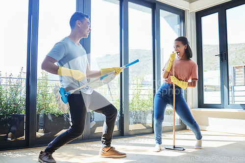 Image of Couple, singing and cleaning home, dance and having fun playing with mop guitar and broom. Clean, dancing and happy man and woman, singer and chores, housekeeping together and happiness for music.