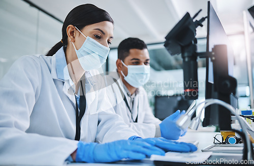 Image of Science, biotechnology and scientists in a laboratory working on research for a medical project. Face mask, equipment and healthcare researchers with a pharmaceutical experiment, test or analysis.