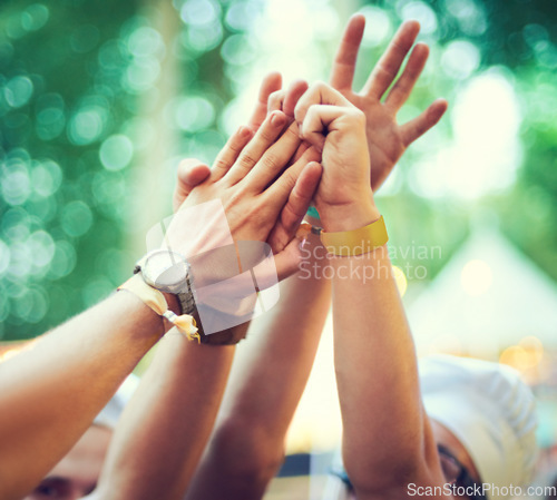 Image of Closeup, hands together and group at event, music festival and outdoor for fun, bonding and collaboration. Zoom, hand and people outside, partying and celebration with social gathering and concert