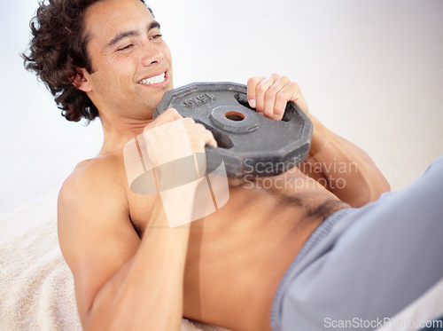 Image of Exercise, situps and man with weight in home for health, wellness and core muscle. Training, weightlifting and male person or strong athlete situp, workout and exercising for bodybuilding or sports.