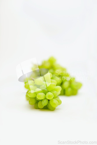 Image of Fruit, green grapes and healthy food in studio for art and creativity for nutritionist. Fruits, wellness diet and nutrition with clean, vegan or grape snack isolated on a white background for health