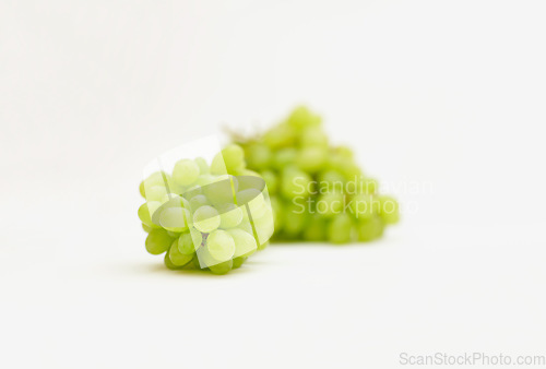 Image of Grapes, green fruit and healthy food in studio for art and creativity for nutritionist. Fruits, wellness diet and nutrition with clean, vegan or grape snack isolated on a white background for health