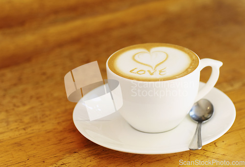 Image of Coffee, latte and wooden table at vintage cafe with a cup at a restaurant with a plain background. Expresso, kitchen and drink with milk and foam at retro diner for breakfast in the morning with love