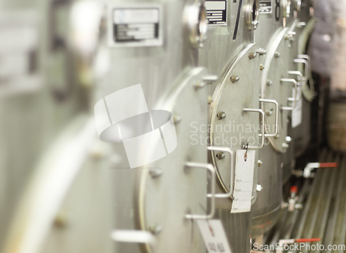 Image of Closeup, stainless steel and fermentation tanks for brewing beer at a breweries, factory or warehouse. Alcohol, machine and barrel at a manufacturing plant for process, fermentation and procedure