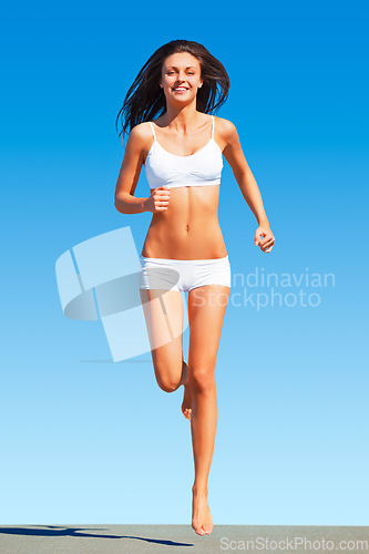 Image of Fitness, portrait and happy woman running in underwear for training, cardio and energy on blue sky background. Sports, face and athletic female runner outdoors for exercise, run and workout routine