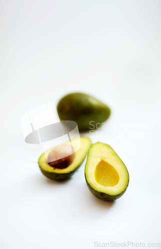 Image of Avocado half, fruit and healthy food in studio with color, art and creativity for nutritionist. Salad, wellness diet and nutrition with clean, green or vegan ingredient isolated on a white background