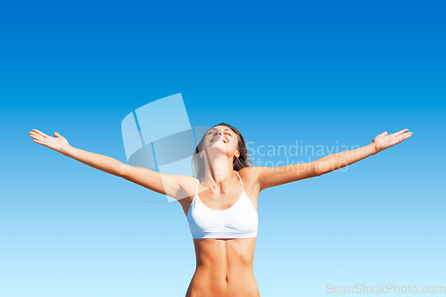 Image of Freedom, woman and sunshine outdoor with happiness and calm feeling with open arms. Blue sky, mindfulness and female person with happy smile and healthy body from sun and celebrate life with wellness