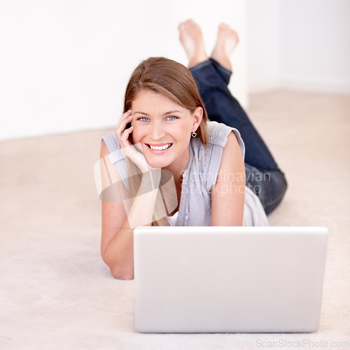 Image of Laptop, portrait and woman laying on the floor browsing on social media, website blog or the internet. Happy, smile and female person relaxing on the ground with a computer for entertainment at home.