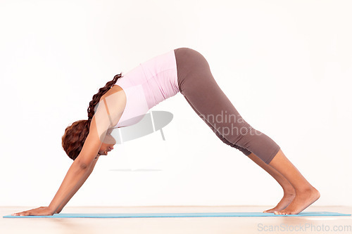 Image of Yoga, body stretching and black woman in studio on a fitness and workout mat for training. Isolated, white background and African female person relax on the ground with downward dog for wellness