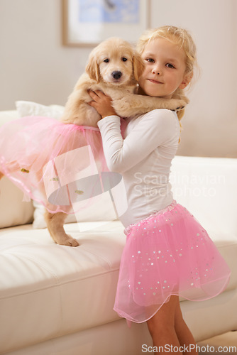 Image of Child, golden retriever and portrait of a dog and happy girl together for love, care and development. Face of a cute kid and animal puppy in a tutu playing dress up as friends on the home sofa