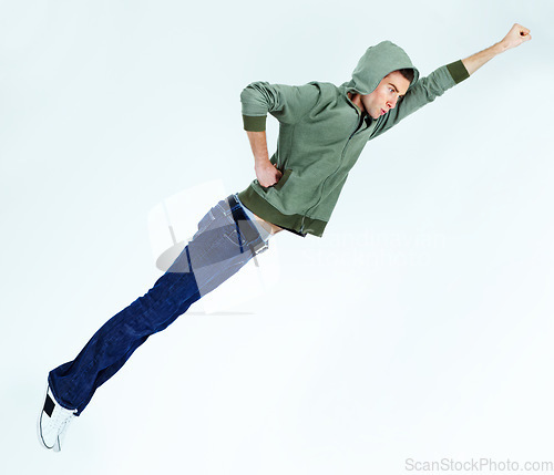 Image of Man in flying, superhero pose with fashion and stylish streetwear casual clothes isolated on white background. Energy, carefree with young male model is soaring and posing in jeans and hoodie