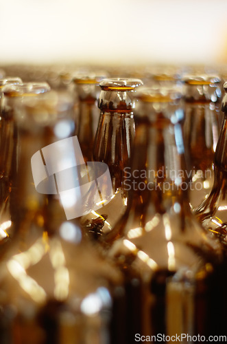 Image of Closeup, row and beer bottles at a factory for manufacturing, produce and small business. Recycling, glass and empty bottle collection for zero waste, reuse and environmental, waste and prevention