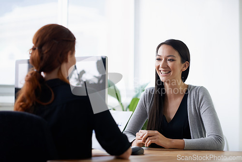 Image of Interview, recruitment and happy business women in office in conversation, talking and chat at desk. Communication, partnership and female workers with documents for meeting, hiring and collaboration