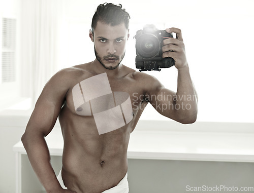 Image of Mirror selfie, body and a man with a camera in the bathroom of his home for health or hygiene. Photography, wellness and fitness with a handsome young male model posing for a photograph in a towel